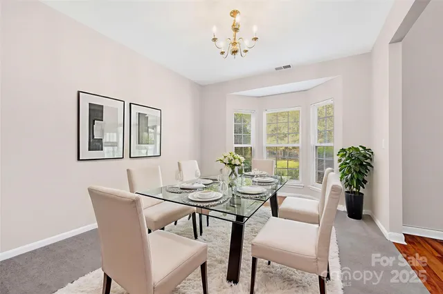 a dining room with furniture potted plants and wooden floor