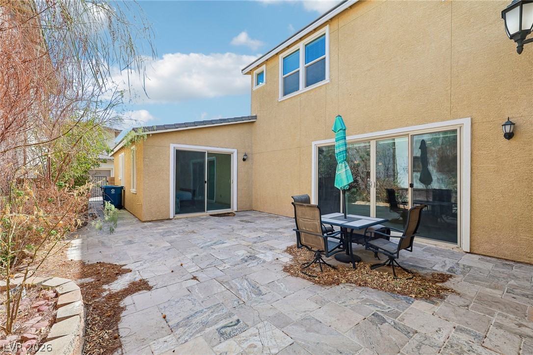 1100 East Sunset Road Henderson, NV 89011 - Photo 44 of 63 A spacious stone-tiled patio expands along the stucco exterior of this multi-level home.