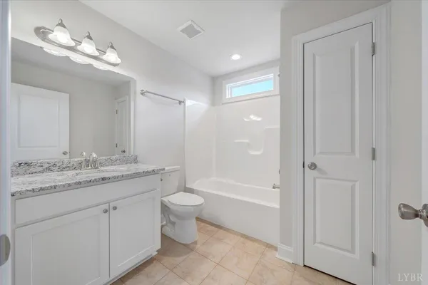a bathroom with a granite countertop sink a toilet and bathtub