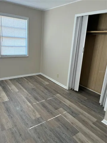 an empty room with closet and windows