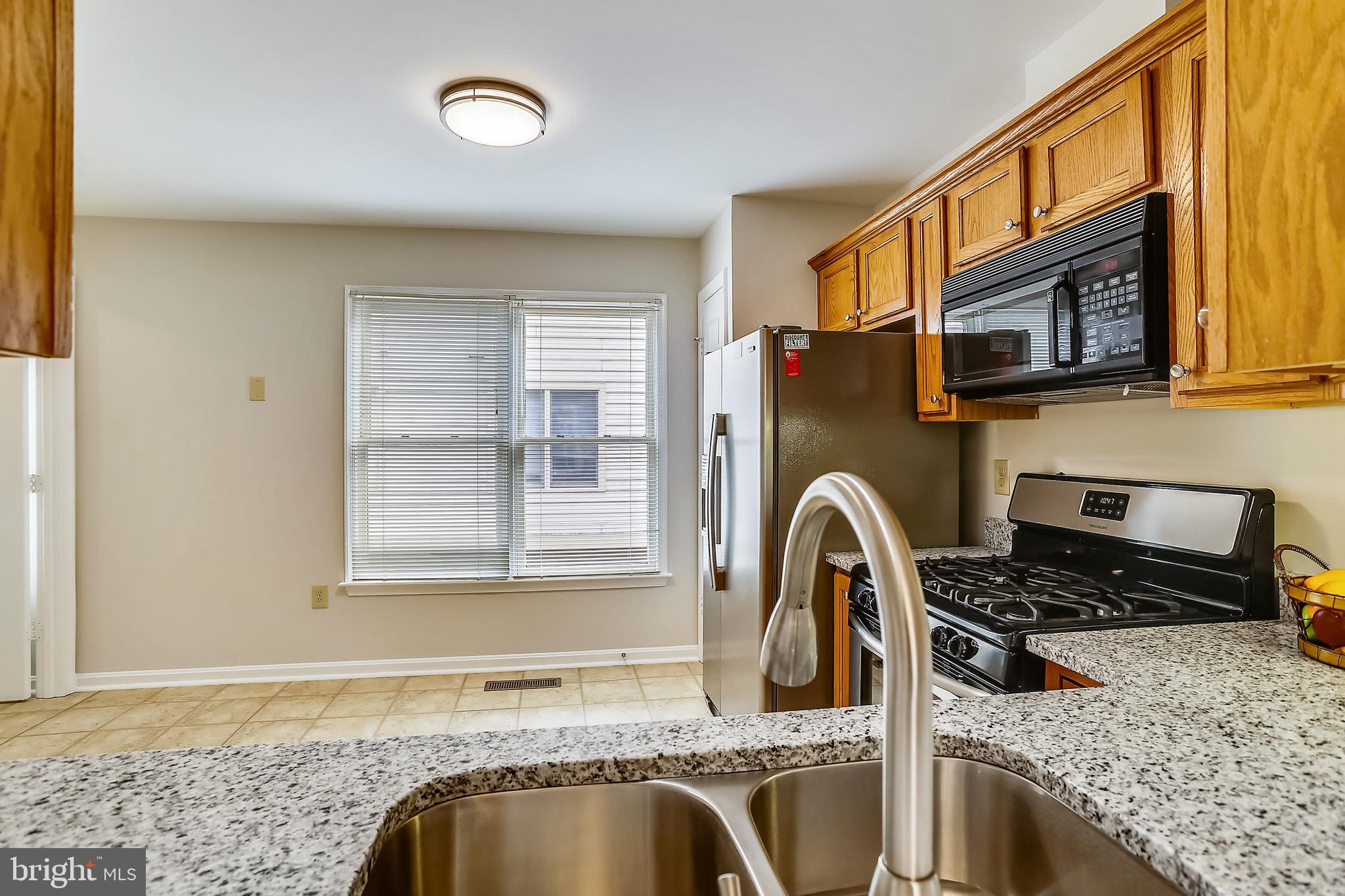 313 Ridgepoint Place Gaithersburg, MD 20878 - Photo 13 of 52 a kitchen with a granite countertop sink stove top oven and microwave