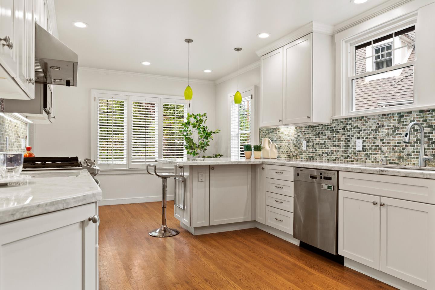 750 Edgewood Road San Mateo, CA 94402 - Photo 13 of 26 a kitchen with granite countertop a stove a sink and white cabinets with wooden floor