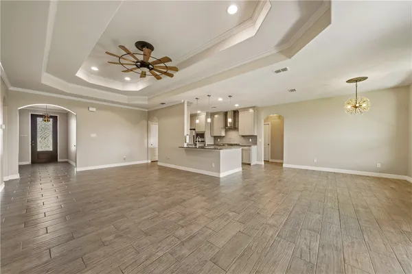 a view of an empty room and kitchen view