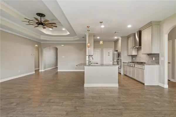 a large white kitchen with a refrigerator a stove top oven a sink and dishwasher