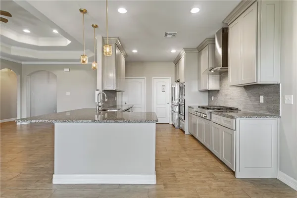 a large kitchen with kitchen island a sink stainless steel appliances and cabinets