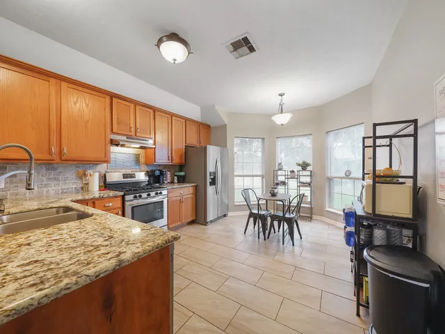 a kitchen with granite countertop a stove oven and sink