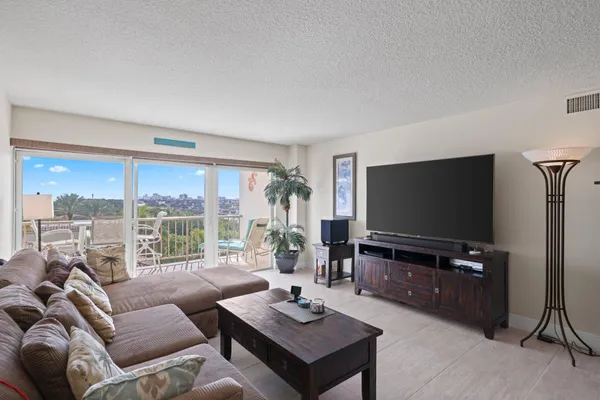 a living room with furniture a flat screen tv and a large window