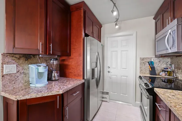 a kitchen with stainless steel appliances granite countertop a sink stove and refrigerator
