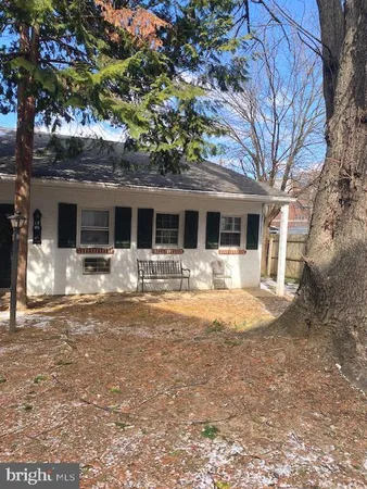 a front view of a house with a yard and large tree