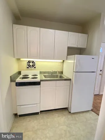 a kitchen with granite countertop white cabinets and white appliances