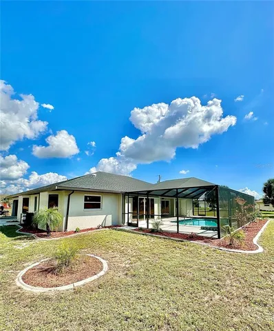 a view of a house with a swimming pool and a yard