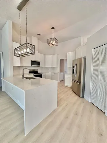 a kitchen with granite countertop stainless steel appliances a stove and a chandelier