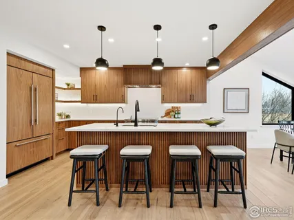 a kitchen with stainless steel appliances granite countertop a table chairs sink refrigerator and microwave