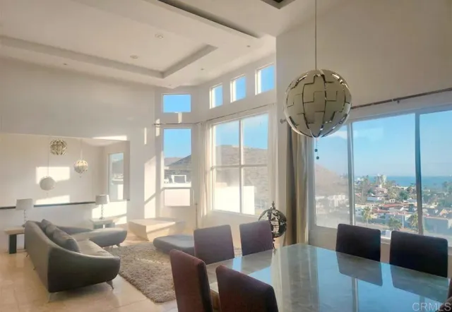 a living room with furniture a chandelier and a large window