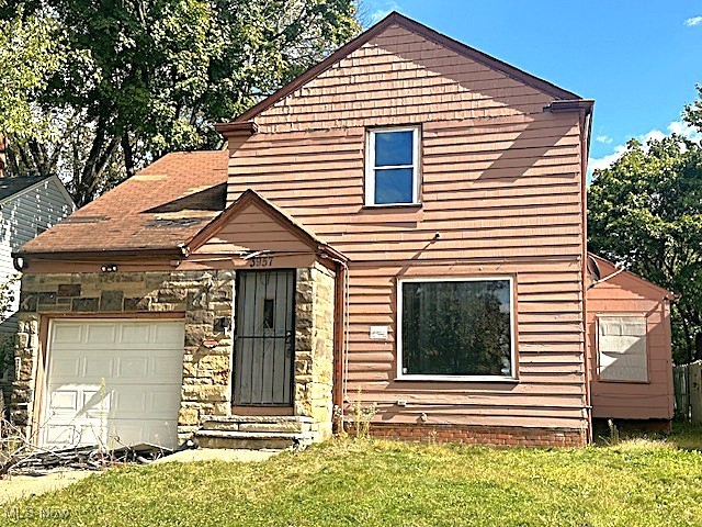3957 Strandhill Road Cleveland, OH 44128 - Photo 1 of 34 View of front of property featuring an attached garage, a front lawn, stone siding, and entry steps