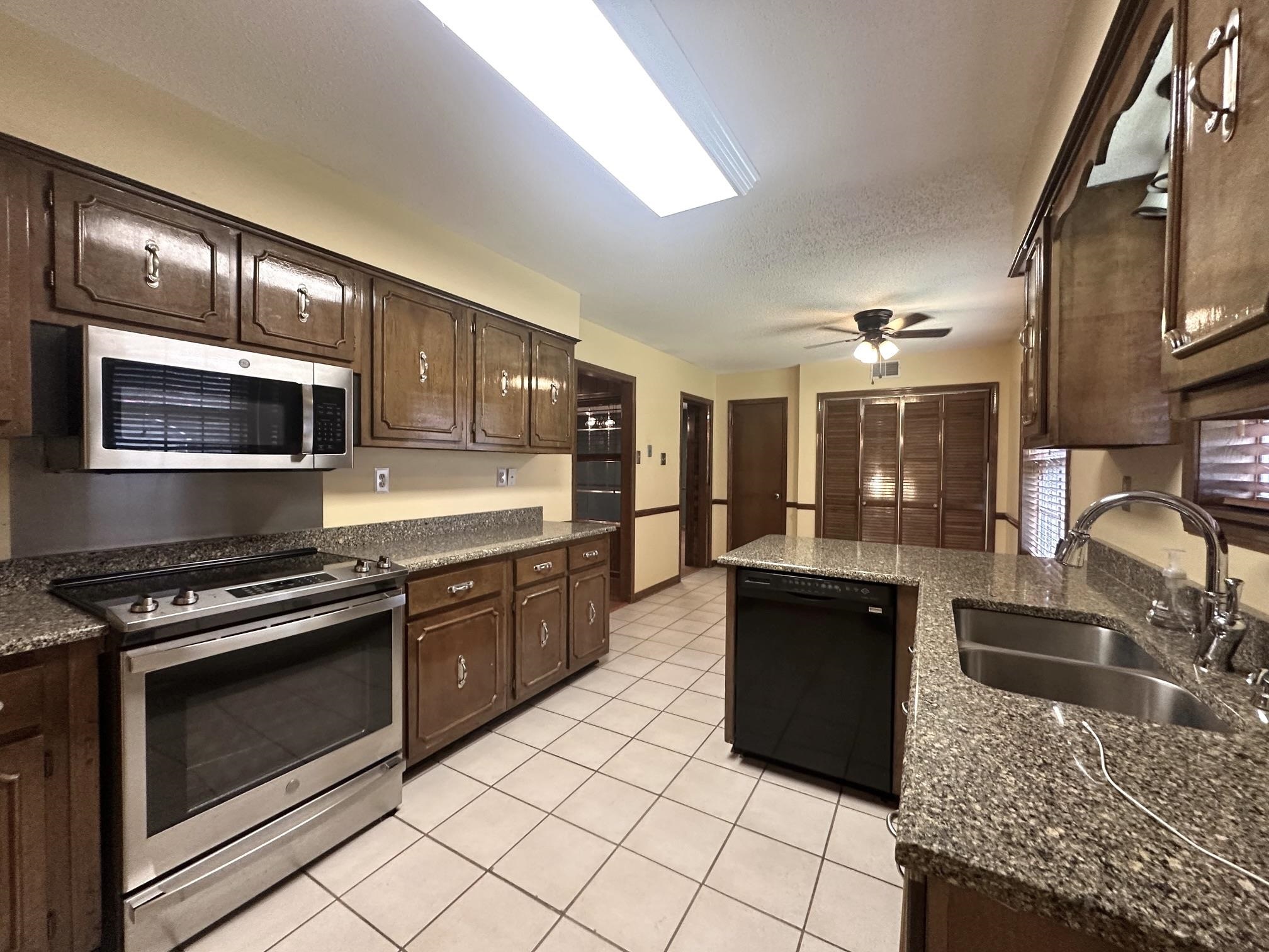 3489 Evening Light Drive Bartlett, TN 38135 - Photo 5 of 30 a kitchen with stainless steel appliances granite countertop a stove a sink and a microwave
