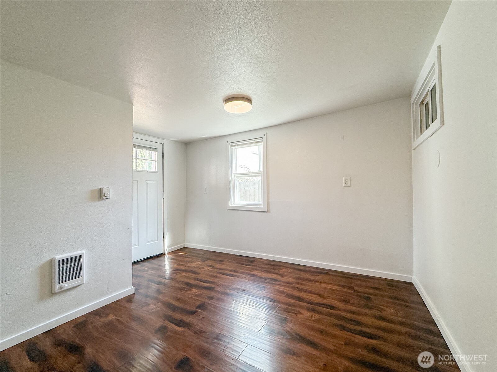 11806 Glendale Way South, Unit AB&C Seattle, WA 98168 - Photo 11 of 16 a view of an empty room with wooden floor and a window