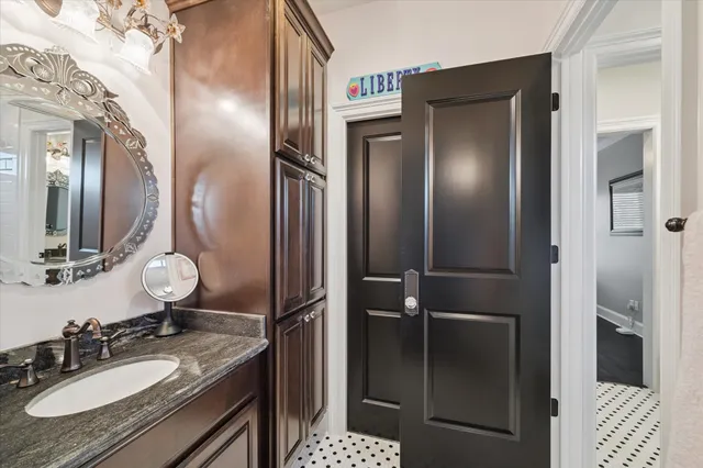 a bathroom with a sink vanity granite shower and a mirror