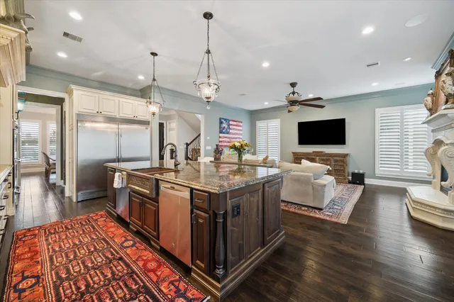 a kitchen with stainless steel appliances granite countertop a stove and a wooden floors