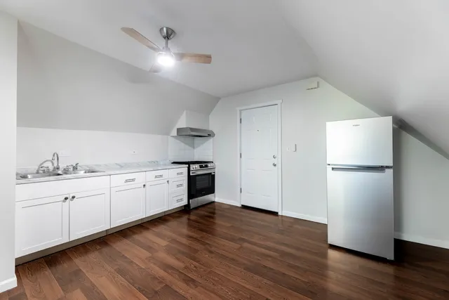 a kitchen with granite countertop white cabinets and white appliances