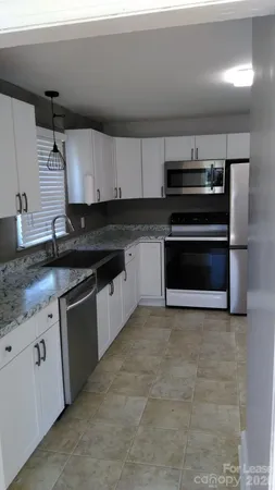 a kitchen with stainless steel appliances granite countertop a sink and a stove