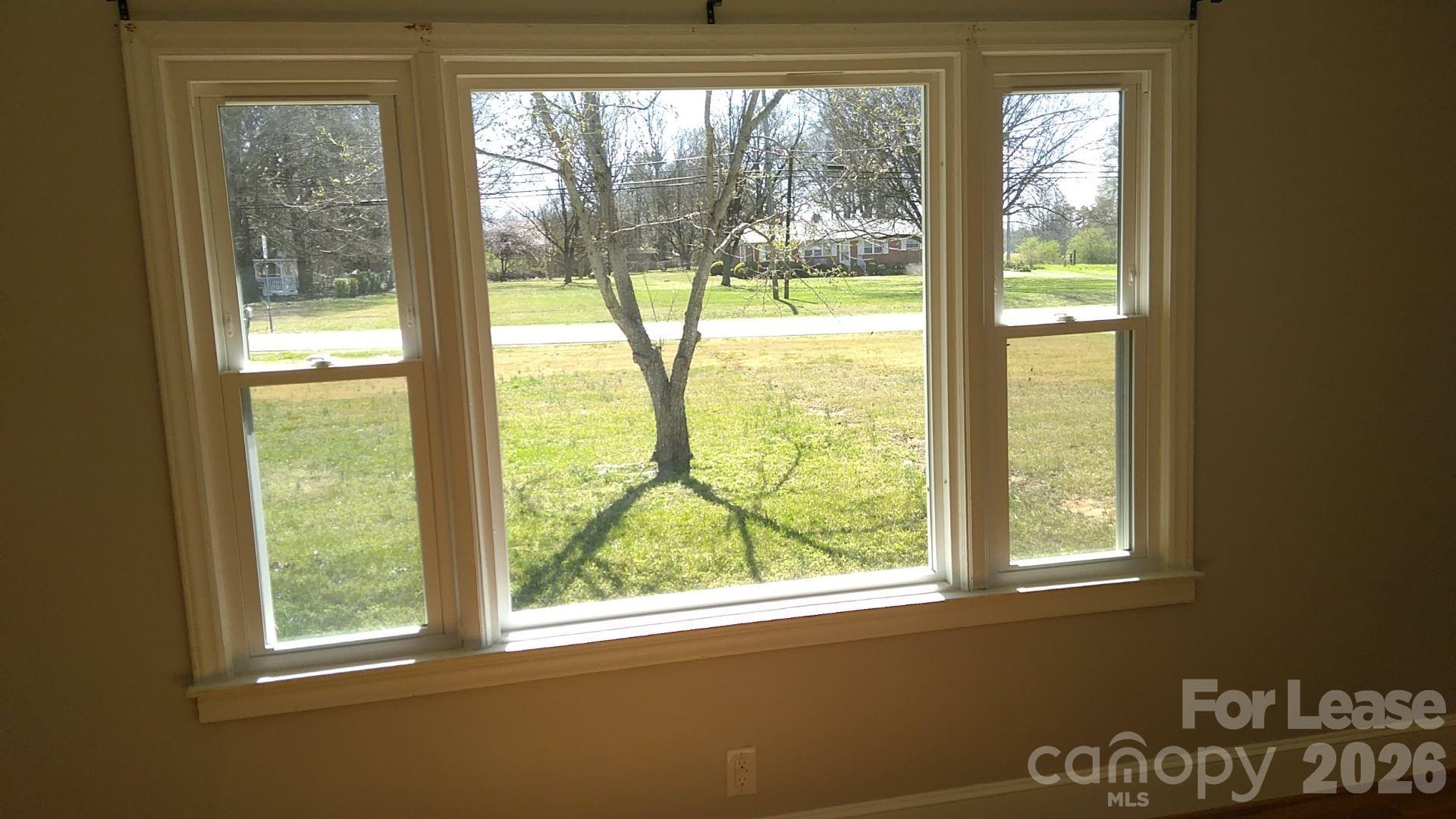 408 West Sandy Ridge Road Monroe, NC 28112 - Photo 10 of 11 a view of an empty room with wooden floor and a window