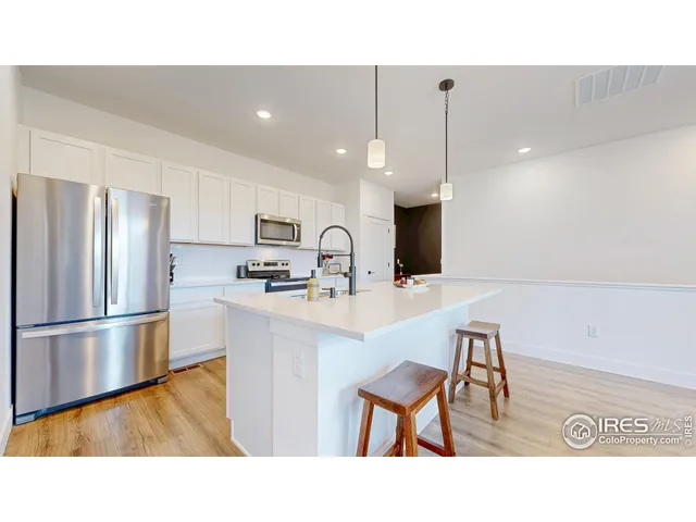 a kitchen with kitchen island a appliances a sink and a refrigerator
