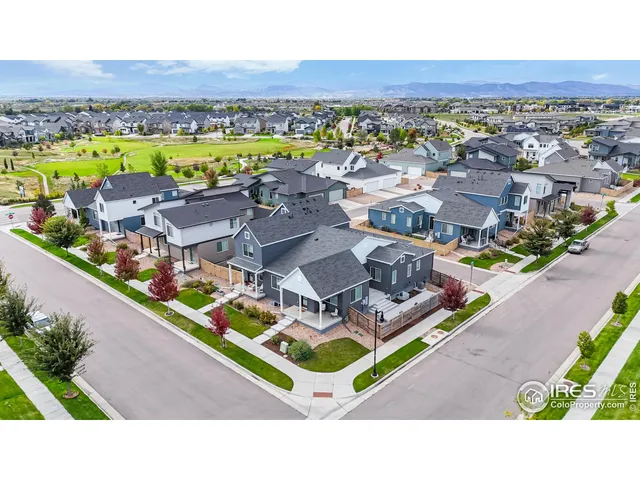 an aerial view of residential houses with outdoor space and ocean view