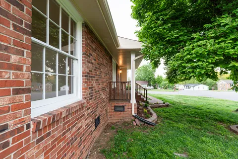 a view of an house with backyard and a tree