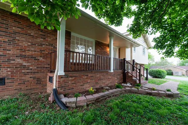 a view of a house with backyard and wooden fence