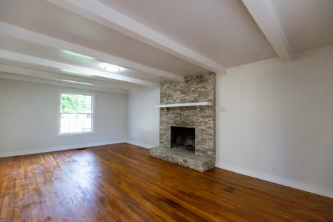 a view of empty room with wooden floor and fireplace