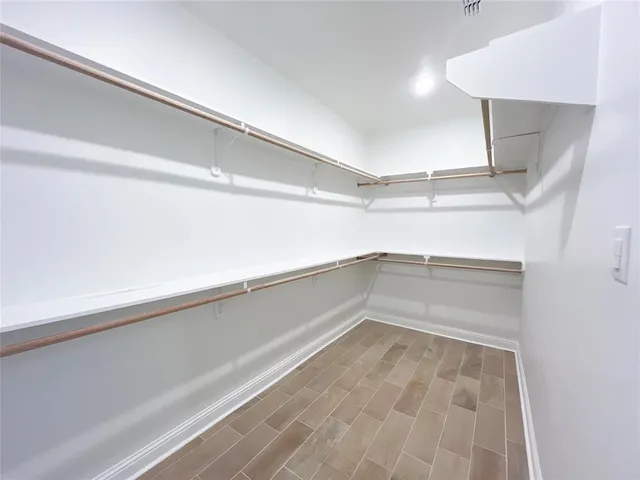 a view of walk in closet with clothes and shoes