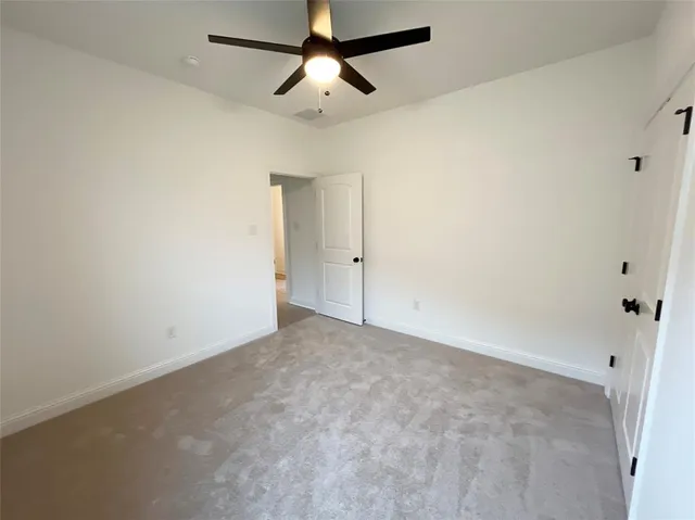 an empty room with chandelier fan