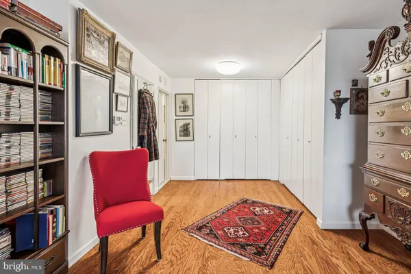 a living room with furniture a bookshelf and a window