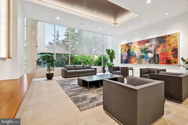 a living room with furniture a floor to ceiling window and flat screen tv
