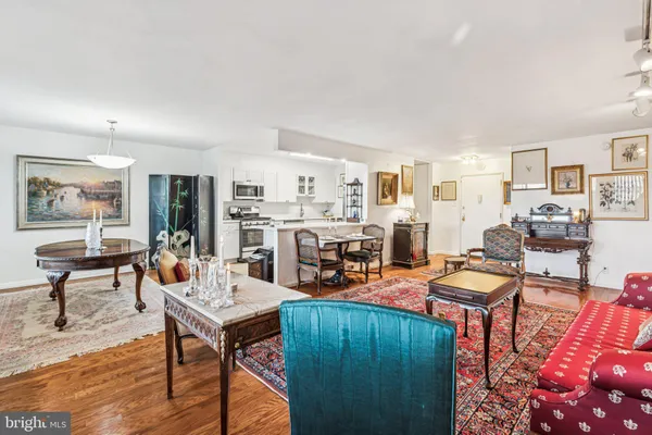 a living room with furniture and a dining table with wooden floor