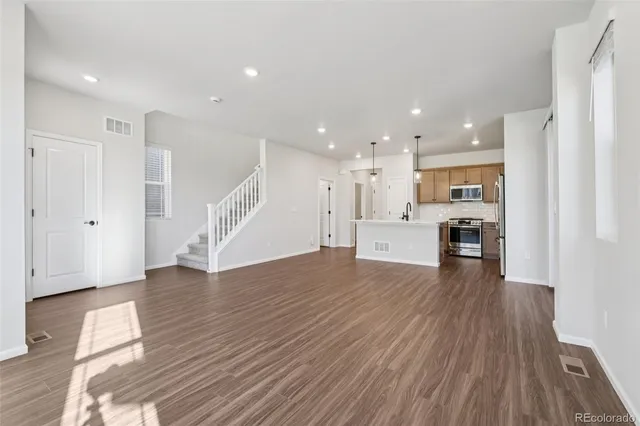 a view of kitchen with wooden floor and electronic appliances