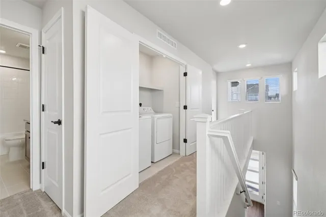 a view of a hallway with white walls and entryway