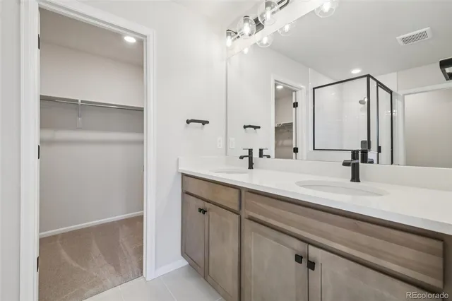 a bathroom with a double vanity sink a mirror and shower