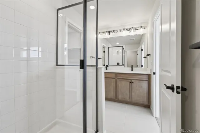 a bathroom with a double vanity sink mirror and shower