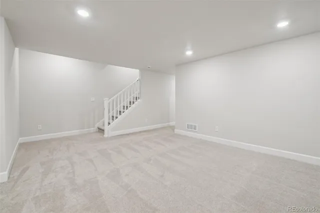 a view of an empty room with stairs and white walls
