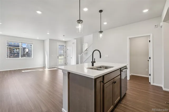 a kitchen with a sink a window and wooden floor