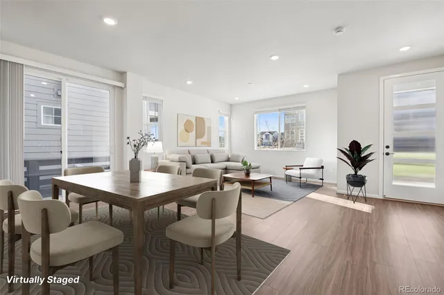 a living room with furniture a wooden floor and next to a window