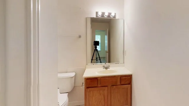a bathroom with a sink a toilet and mirror