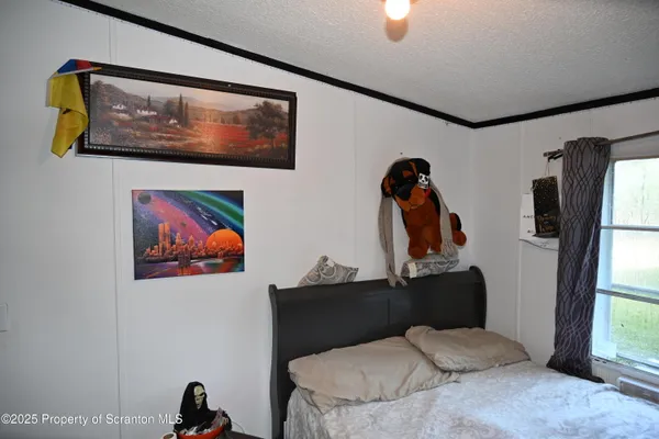 a bedroom with a bed and a painting on the wall