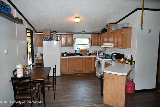 a kitchen with refrigerator cabinets and wooden floor