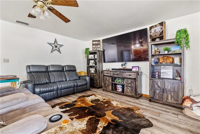 a view of a livingroom with wooden floor and furniture