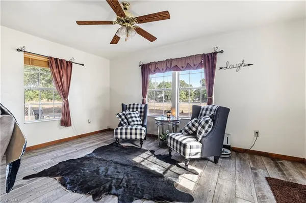 a view of a livingroom with wooden floor and furniture