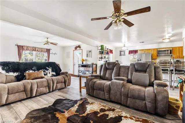 a living room with furniture a ceiling fan and a rug