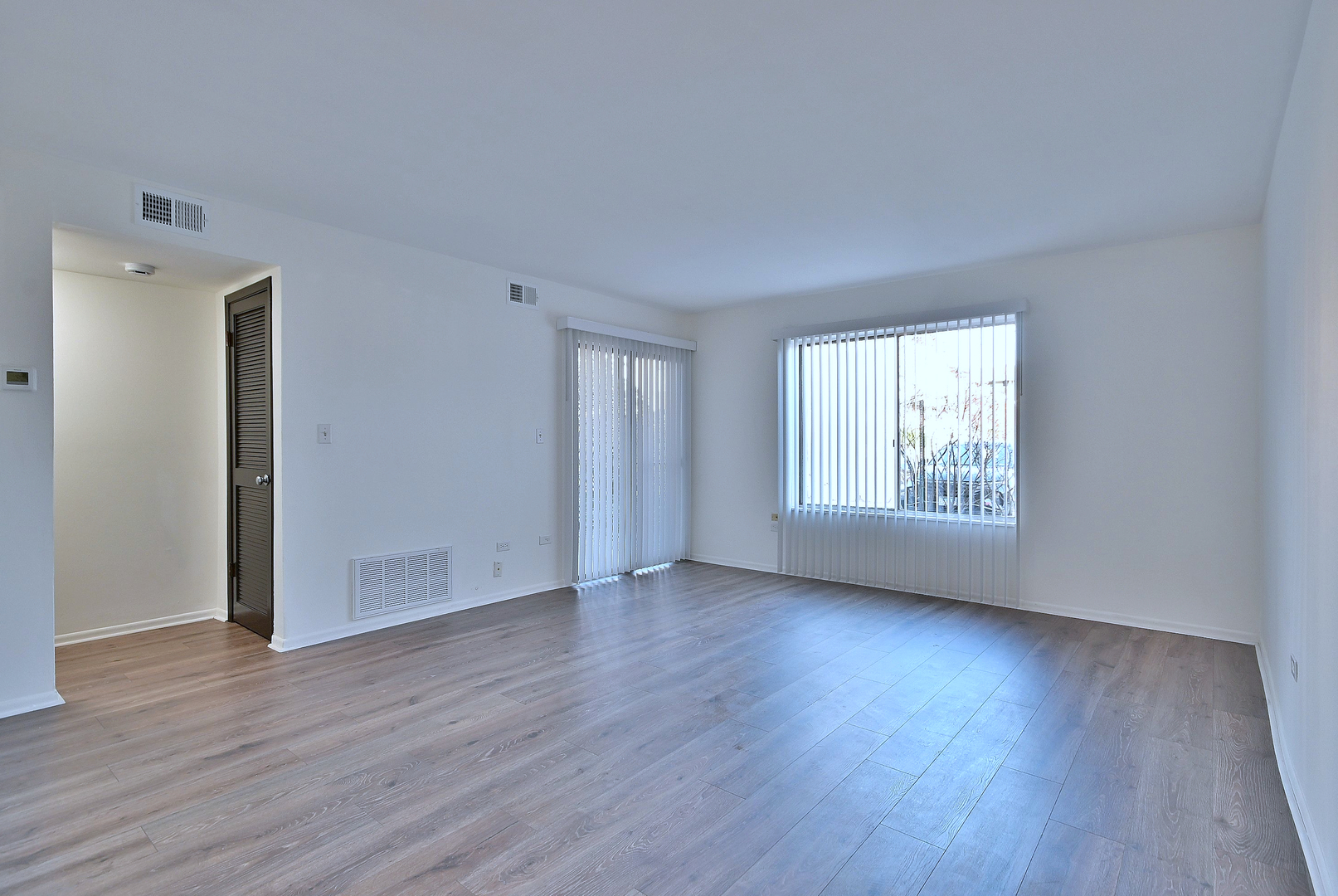 6177 Knoll Wood Road, Unit 102 Willowbrook, IL 60527 - Photo 2 of 19 an empty room with wooden floor and windows